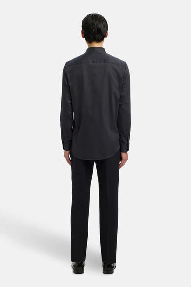 Chemise à manches longues noire de SELECTED, vue de dos, portée avec un pantalon noir et des chaussures habillées.