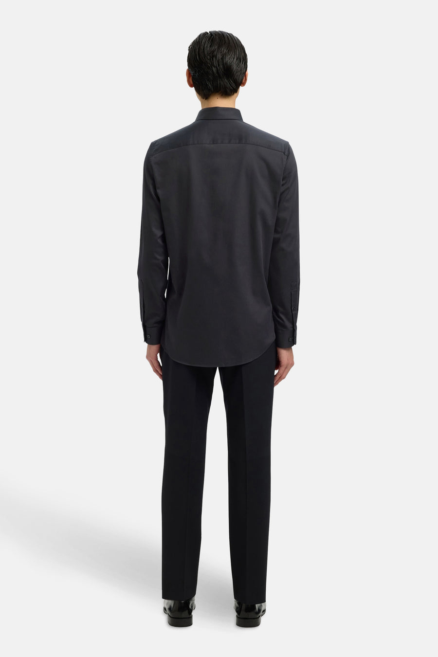 Chemise à manches longues noire de SELECTED, vue de dos, portée avec un pantalon noir et des chaussures habillées.