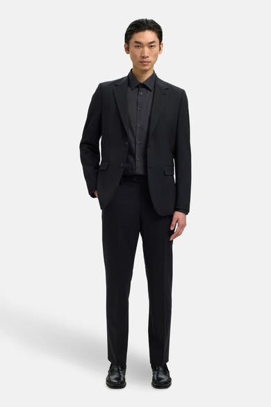 Chemise noire à manches longues de SELECTED, portée avec un costume noir assorti.