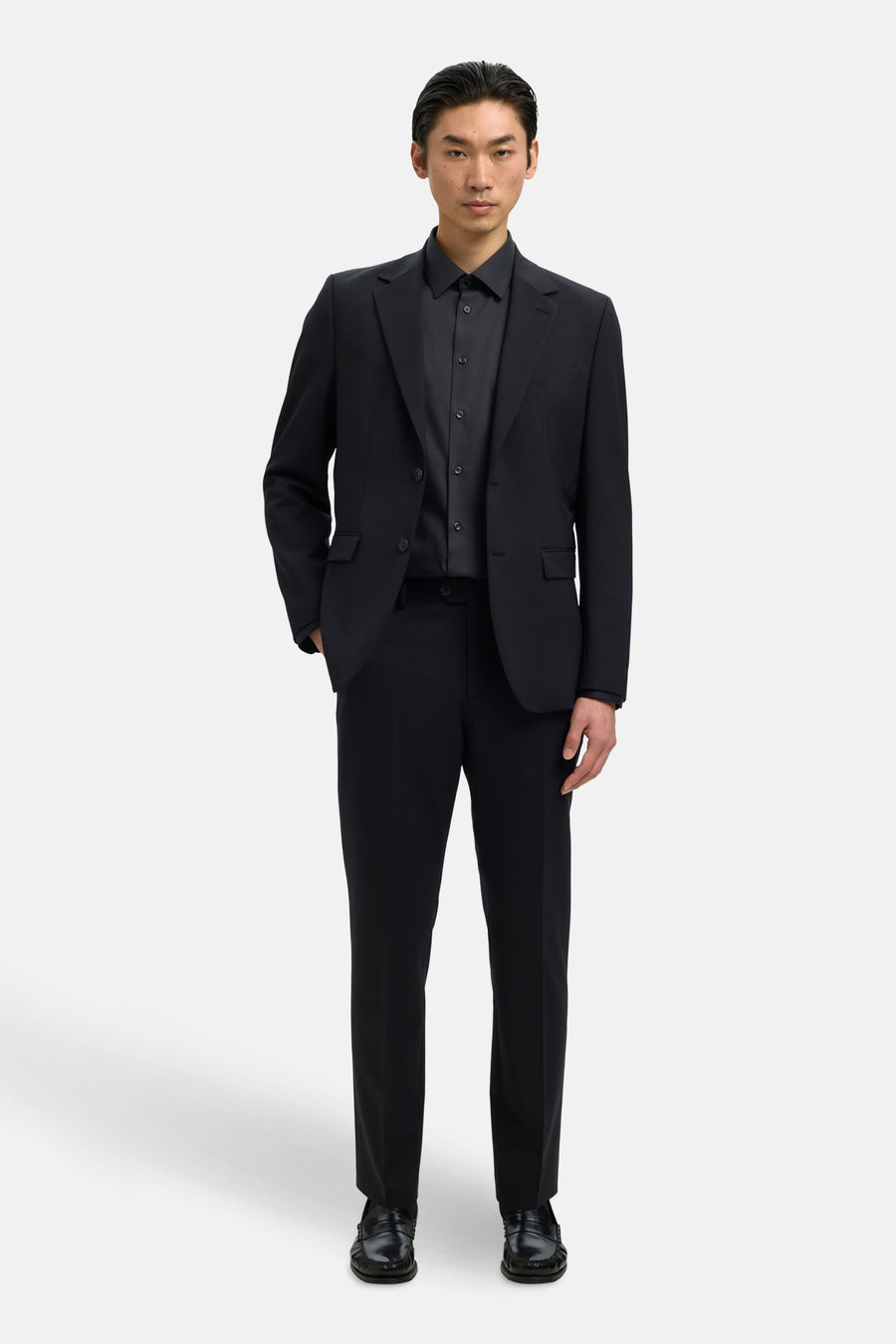 Chemise noire à manches longues de SELECTED, portée avec un costume noir assorti.