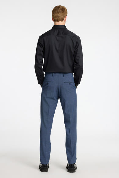 Chemise noire à manches longues de SELECTED, portée avec un pantalon bleu texturé, vue de dos.