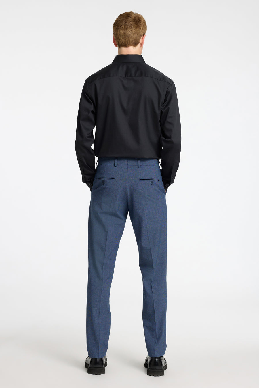 Chemise noire à manches longues de SELECTED, portée avec un pantalon bleu texturé, vue de dos.