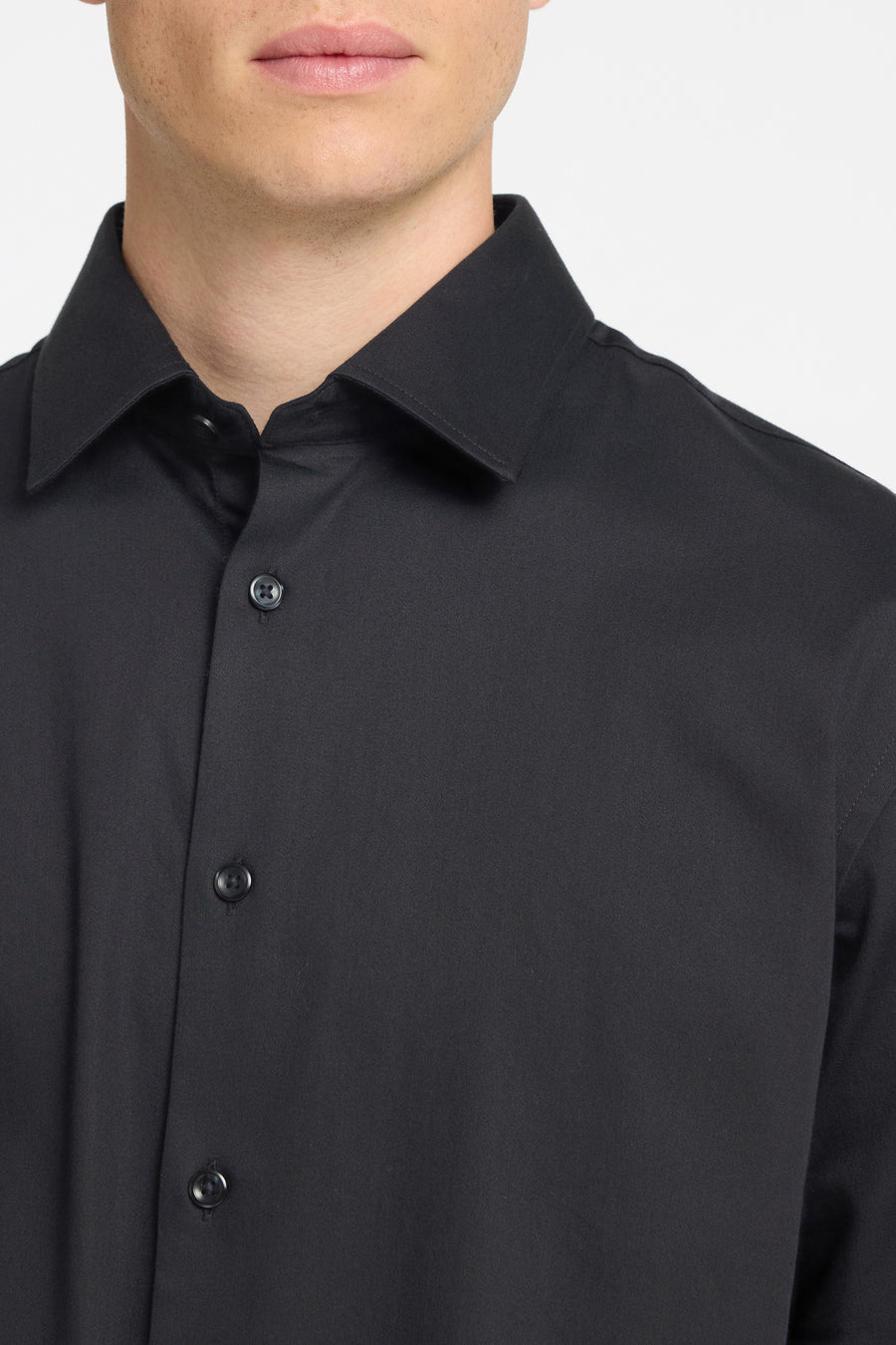 Chemise noire à manches longues de SELECTED, montrant des boutons et le col sur un fond blanc.
