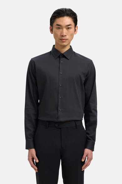 Chemise noire à manches longues de SELECTED, portée avec un pantalon noir assorti.