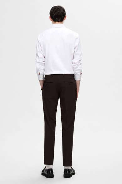 Chemise blanche à manches longues de SELECTED, portée avec un pantalon marron et des mocassins noirs.