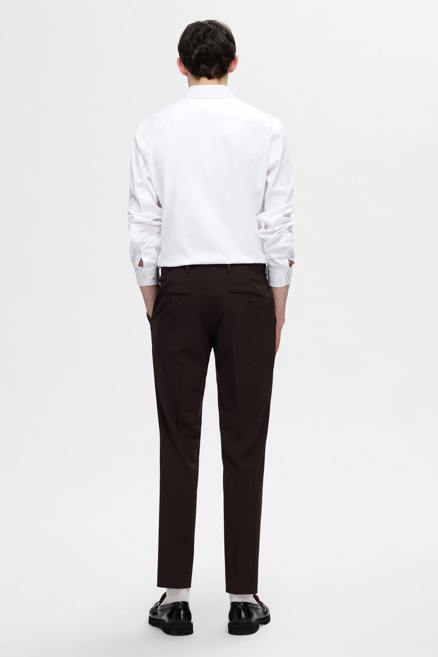 Chemise blanche à manches longues de SELECTED, portée avec un pantalon marron et des mocassins noirs.