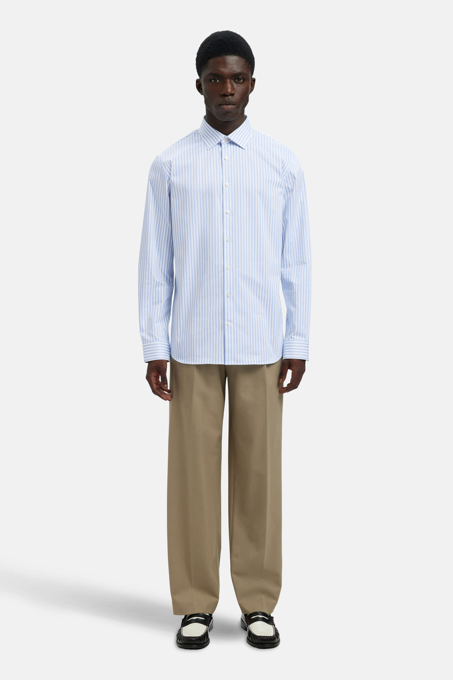 Chemise bleue rayée à manches longues de SELECTED, portée avec un pantalon beige ample et des mocassins.