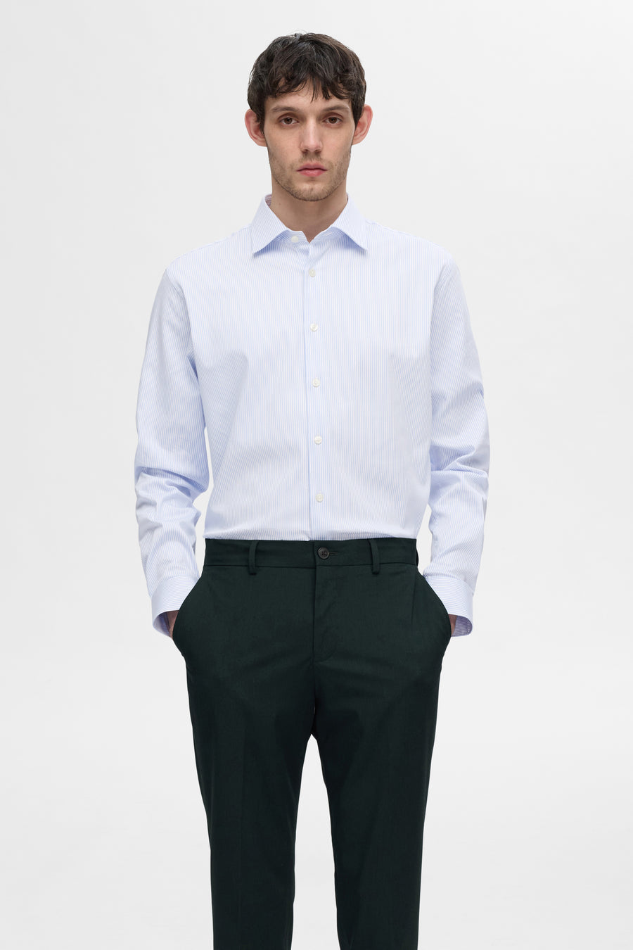 Chemise à manches longues blanche à rayures de SELECTED, portée avec un pantalon vert foncé.
