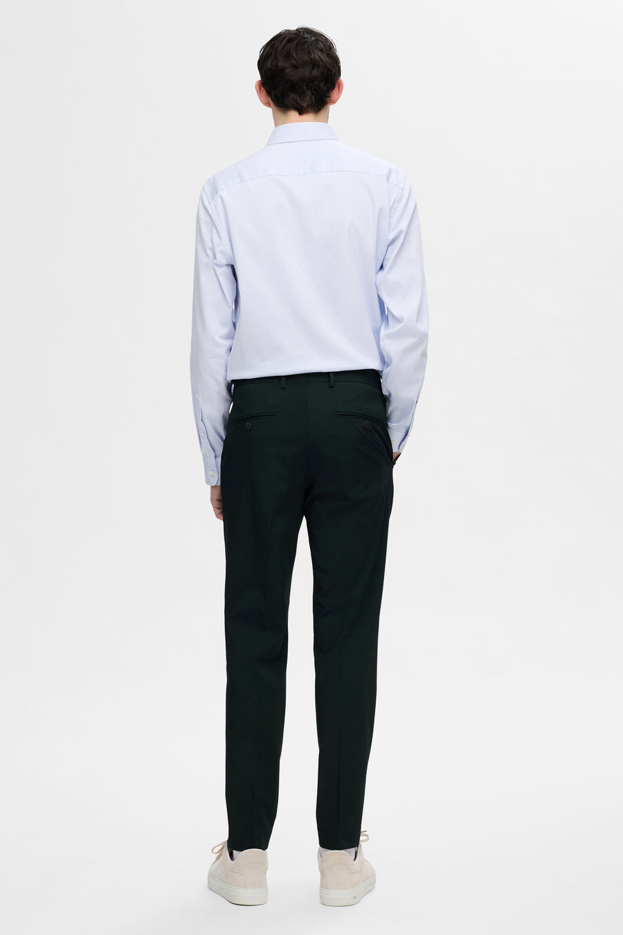 Chemise à manches longues blanche rayée de SELECTED, portée avec un pantalon foncé et des chaussures de sport beiges, vue de dos.
