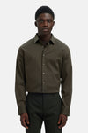 Chemise à manches longues verte de SELECTED, portée avec un pantalon sombre assorti.