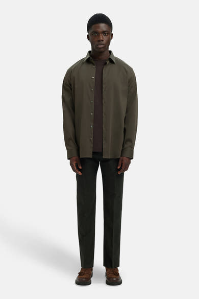 Chemise à manches longues verte de SELECTED, portée sur un t-shirt marron avec un pantalon et des chaussures marron.