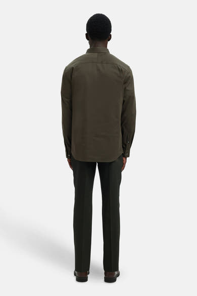 Chemise à manches longues verte de SELECTED, vue de dos, portée avec un pantalon et des chaussures marron foncé.
