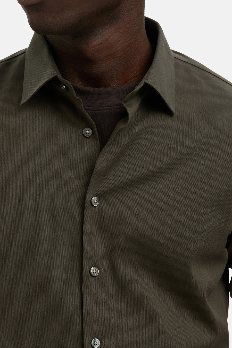 Chemise à manches longues verte de SELECTED, portée sur un t-shirt marron, texture à chevrons.