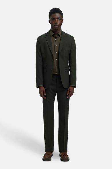 Chemise à manches longues verte par SELECTED, portée sous un veston et un pantalon assortis, avec des chaussures marron à glands.
