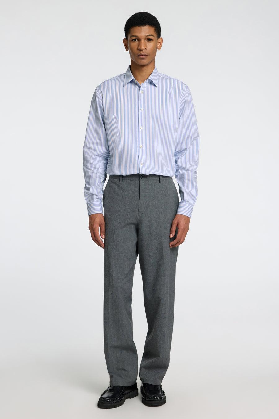 Chemise à manches longues bleu et blanc rayée par SELECTED, portée avec un pantalon gris anthracite uni.