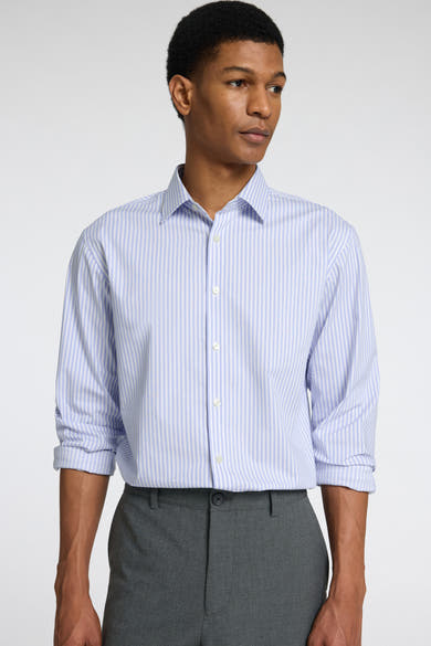 Chemise à manches longues bleue rayée de SELECTED, portée avec un pantalon gris uni.