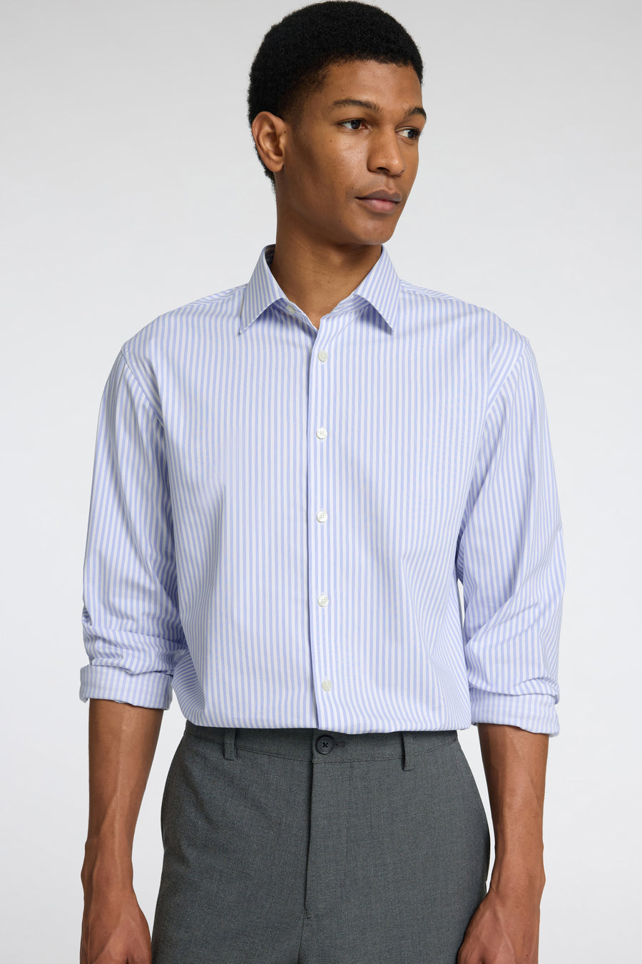 Chemise à manches longues bleue rayée de SELECTED, portée avec un pantalon gris uni.