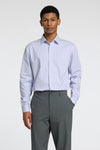 Chemise à manches longues bleue à rayures, de SELECTED, portée avec un pantalon gris uni.