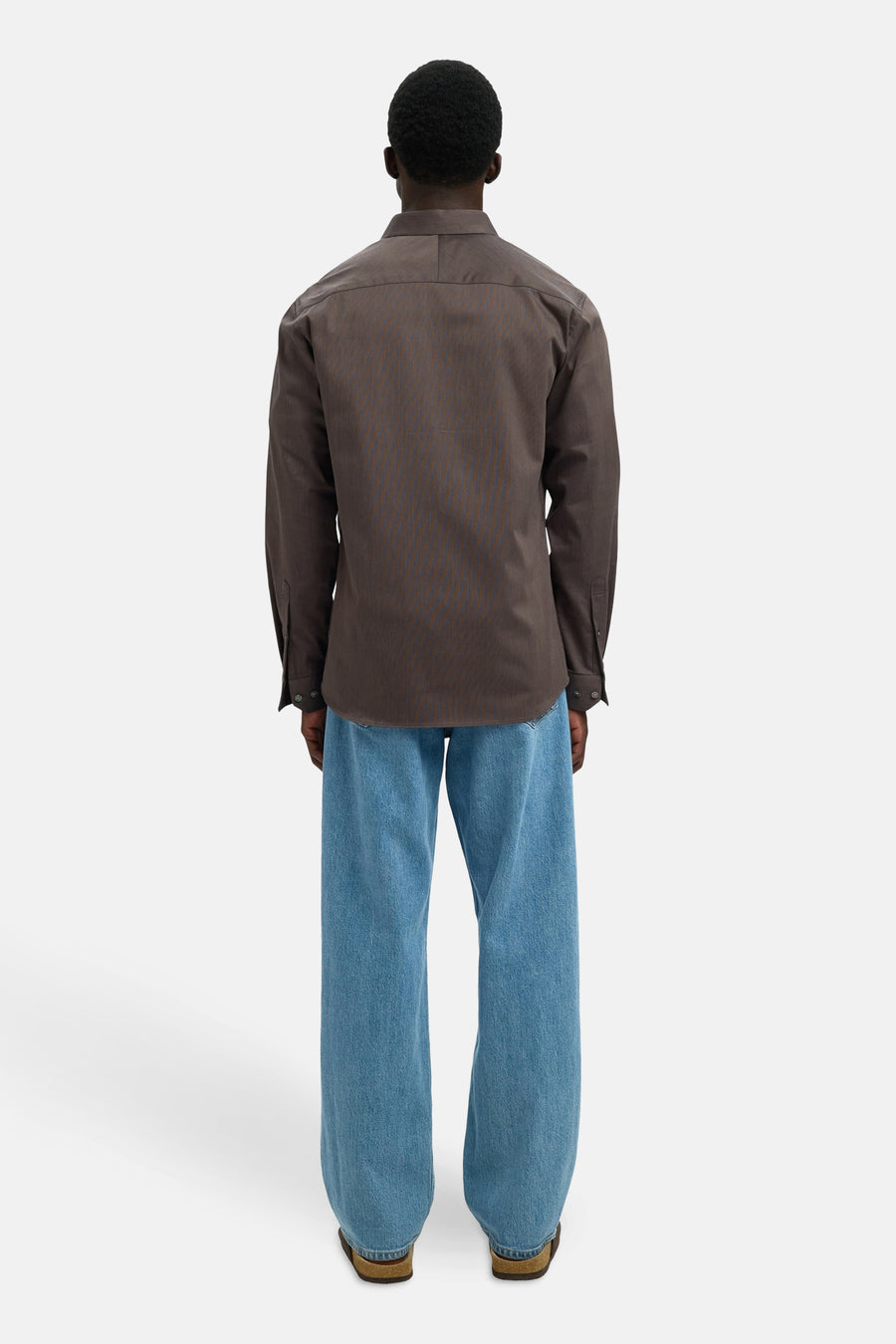 Chemise à manches longues marron à rayures fines de SELECTED, portée avec un jean bleu ample.