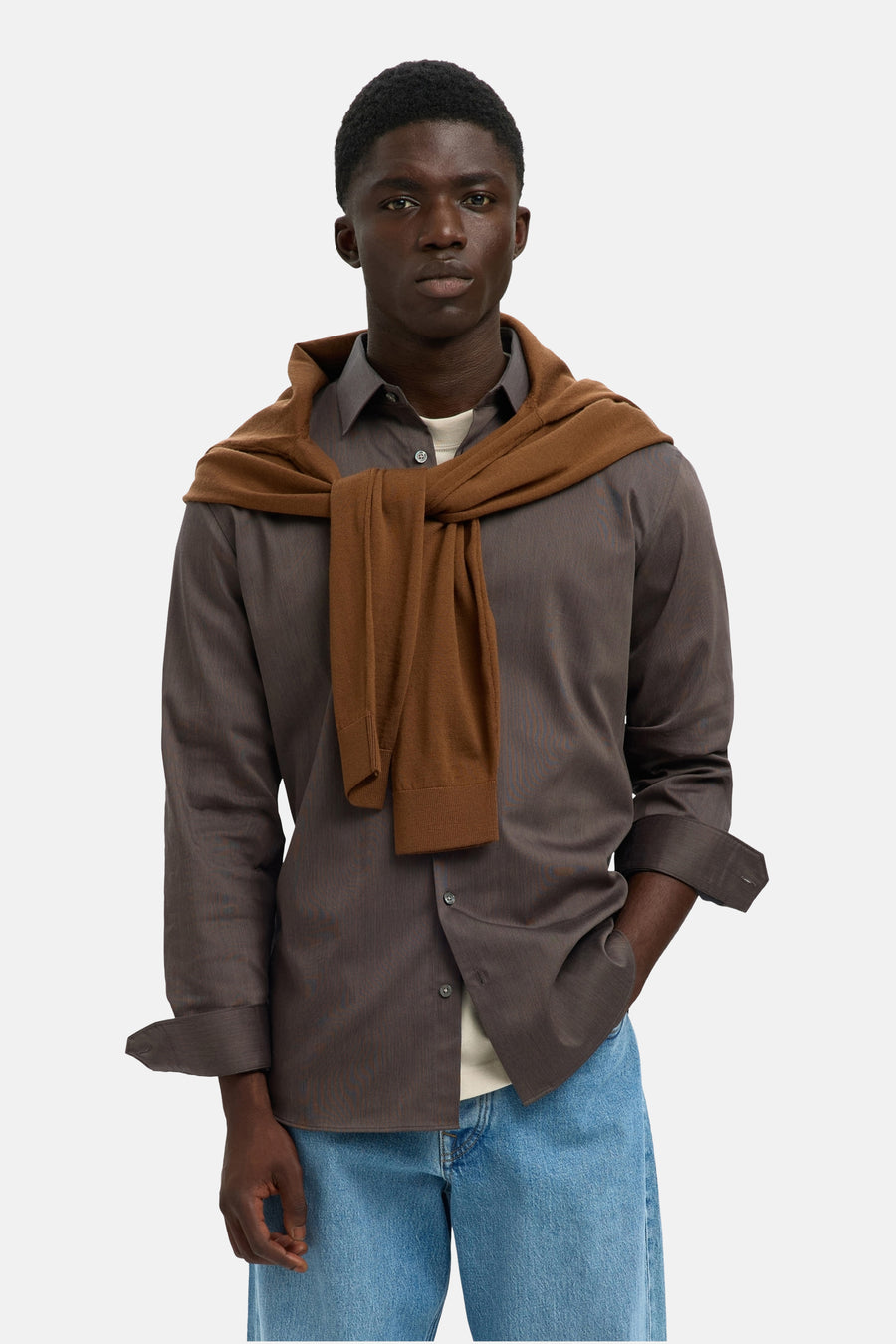 Chemise à manches longues marron SELECTED, portée avec un pull noué et un jean bleu clair.