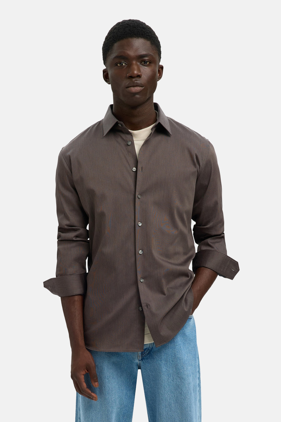 Chemise à manches longues marron de SELECTED, portée sur un t-shirt clair, avec un jean bleu.