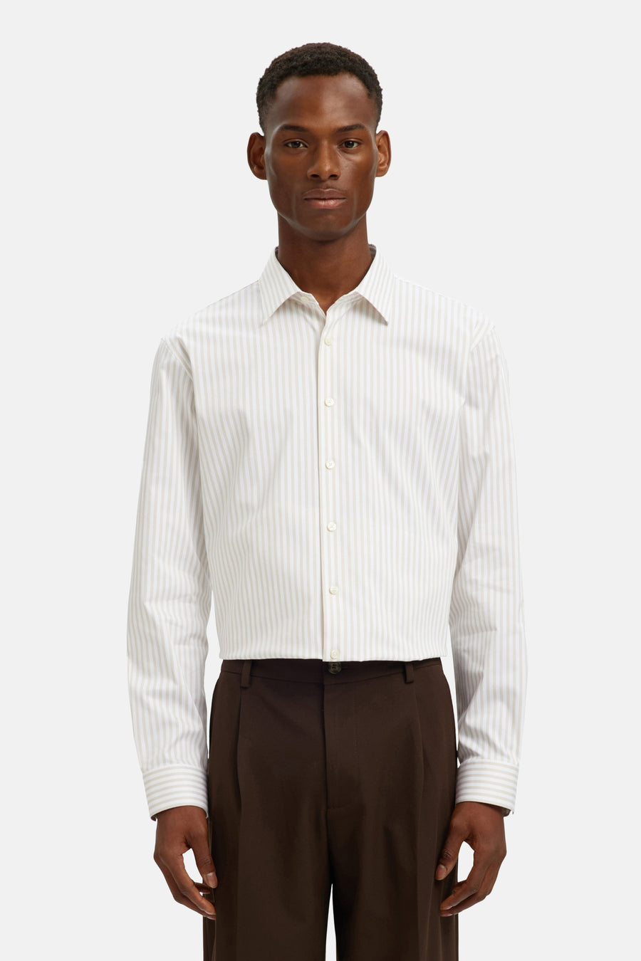 Chemise à manches longues beige, rayée, de SELECTED, portée avec un pantalon marron.
