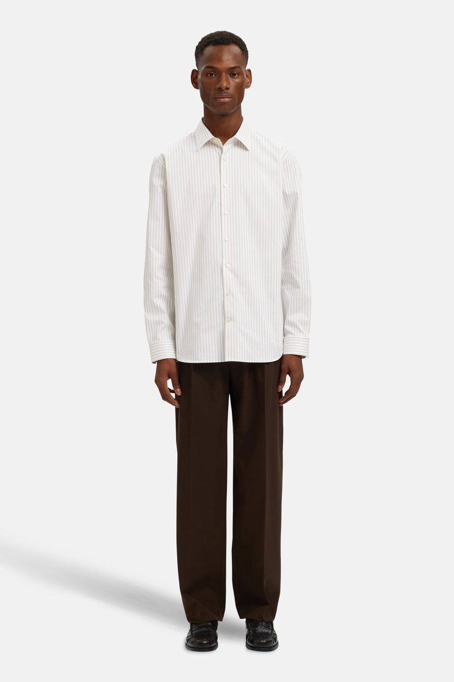 Chemise à manches longues beige à rayures verticales de SELECTED, portée avec un pantalon marron ample.
