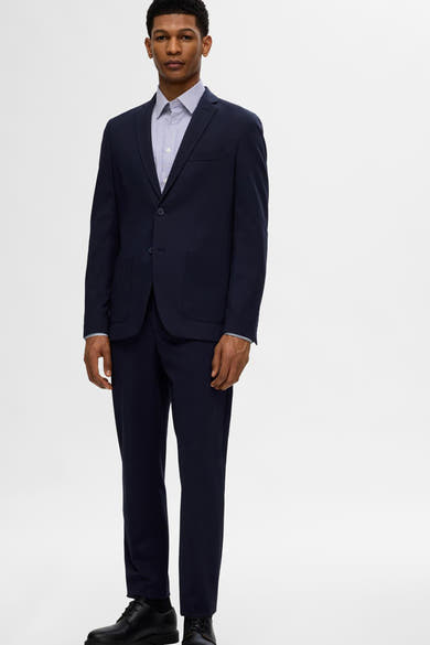 Chemise à manches longues bleue rayée de SELECTED, portée sous un costume bleu marine uni avec des chaussures noires.

