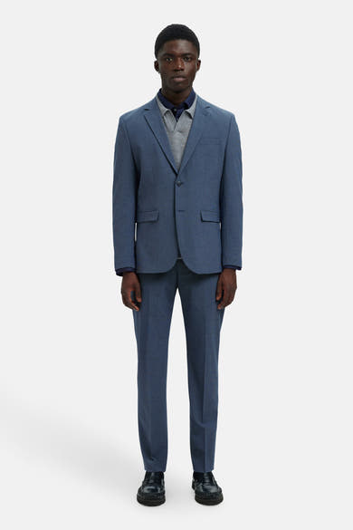 Blazer bleu par SELECTED, porté avec un polo bleu marine et un pull gris.