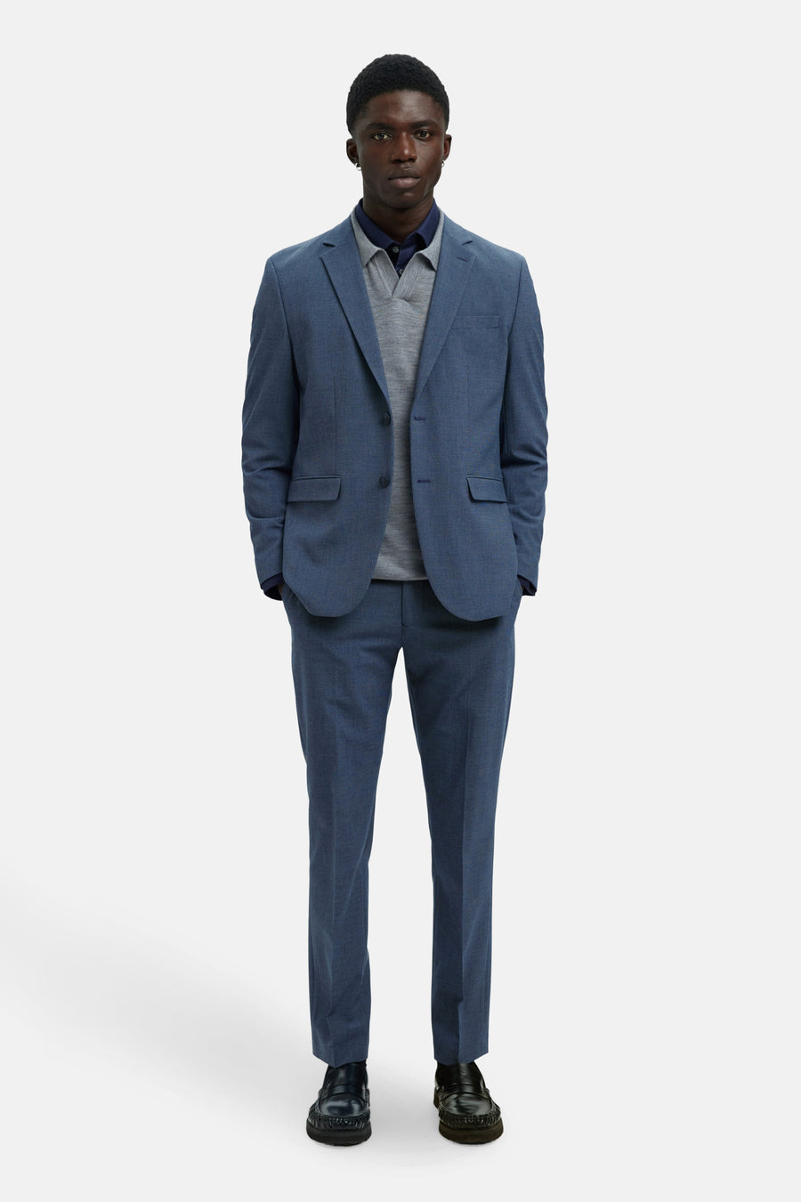 Blazer bleu de SELECTED, porté avec un pull gris et des mocassins noirs.