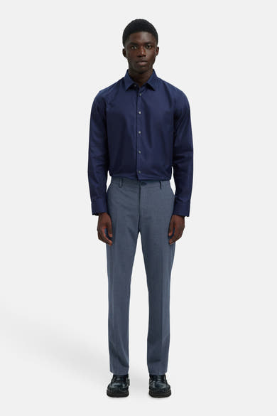 Pantalon de costume bleu par SELECTED, porté avec une chemise bleu marine et des mocassins noirs.