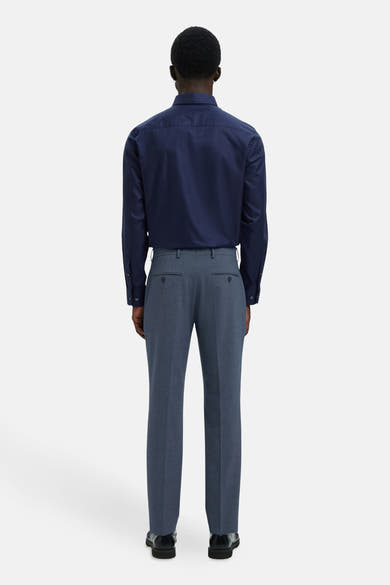 Pantalon de costume bleu de SELECTED, coupe classique, porté avec une chemise bleue et des chaussures noires, vue de dos.
