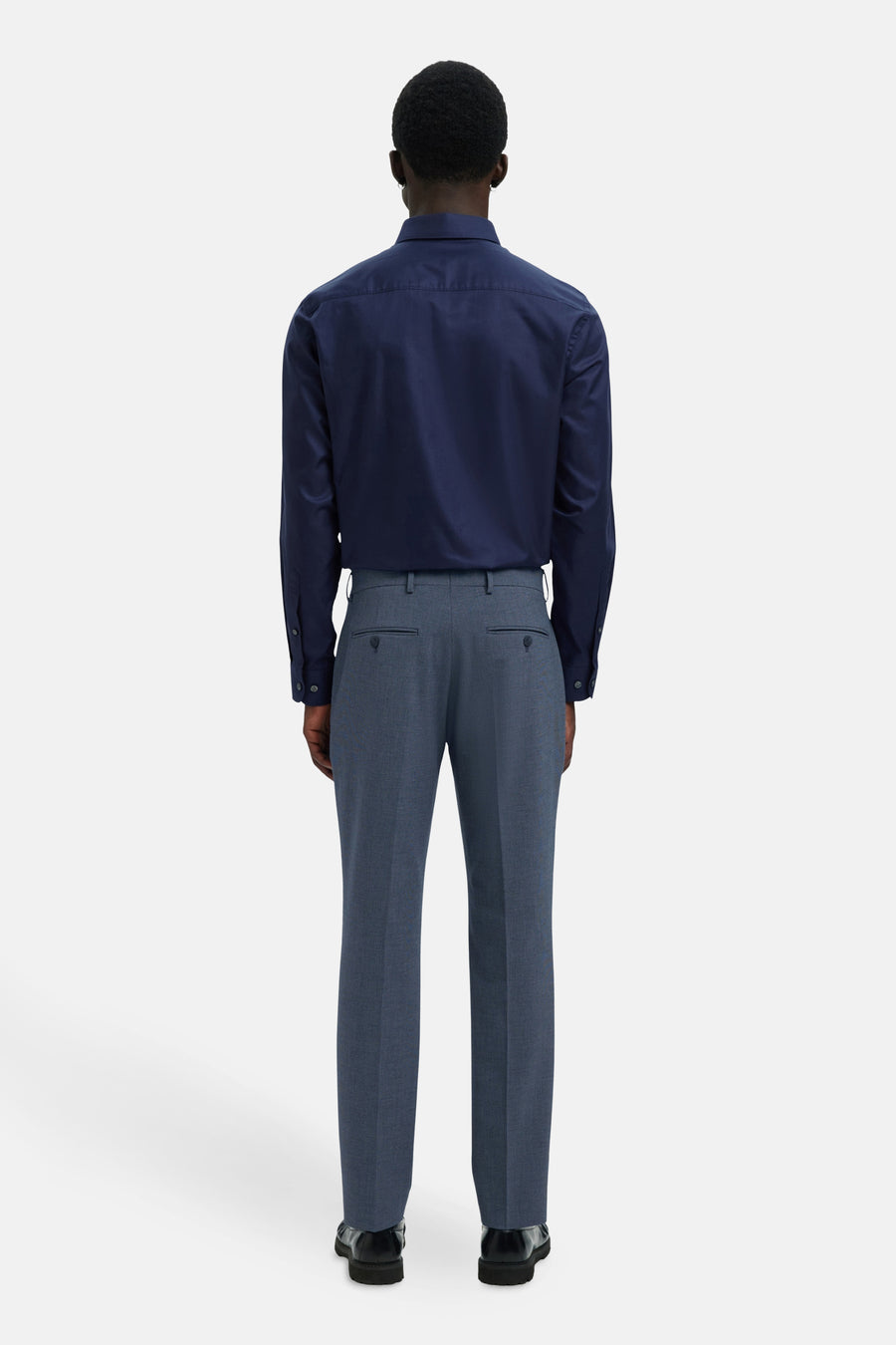 Pantalon de costume bleu de SELECTED, coupe classique, porté avec une chemise bleue et des chaussures noires, vue de dos.
