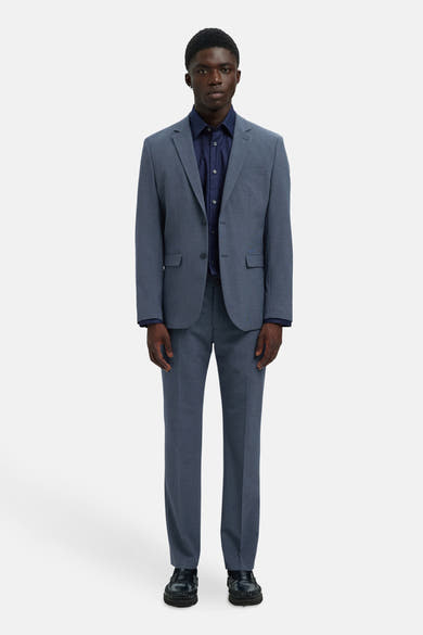 Pantalon de costume bleu de SELECTED, porté avec une chemise bleu foncé et des chaussures noires.