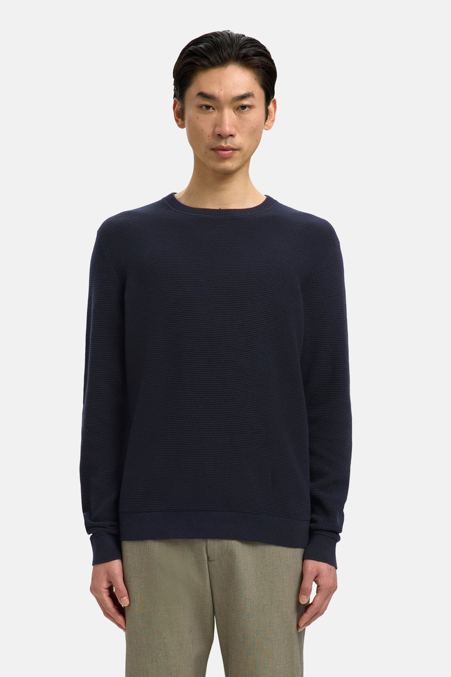 Donkerblauwe coltrui van SELECTED, gedragen met een beige broek en zwarte loafers.