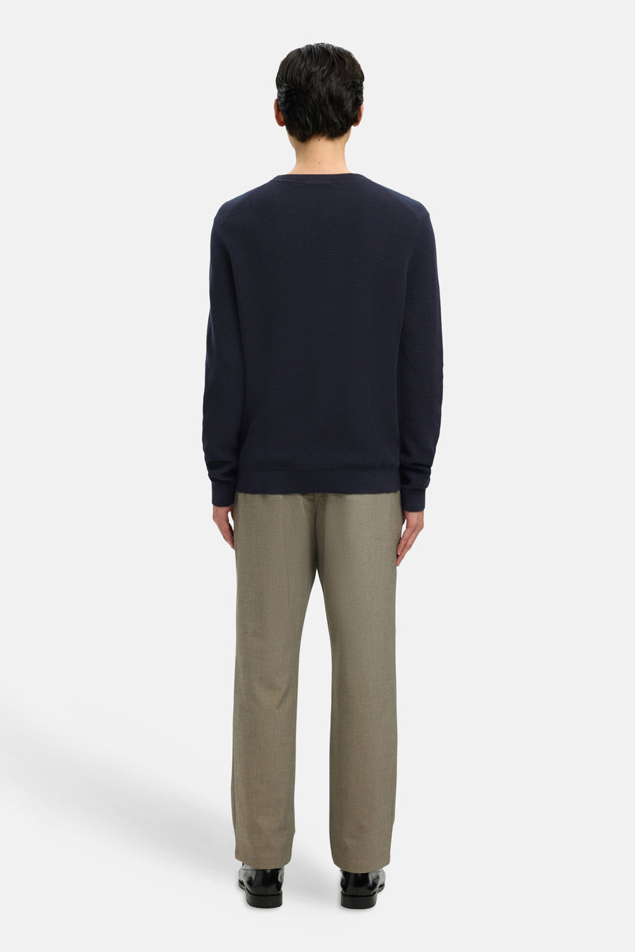 Donkerblauwe rondehals trui van SELECTED, gedragen met een beige broek en zwarte schoenen, achtergezicht.