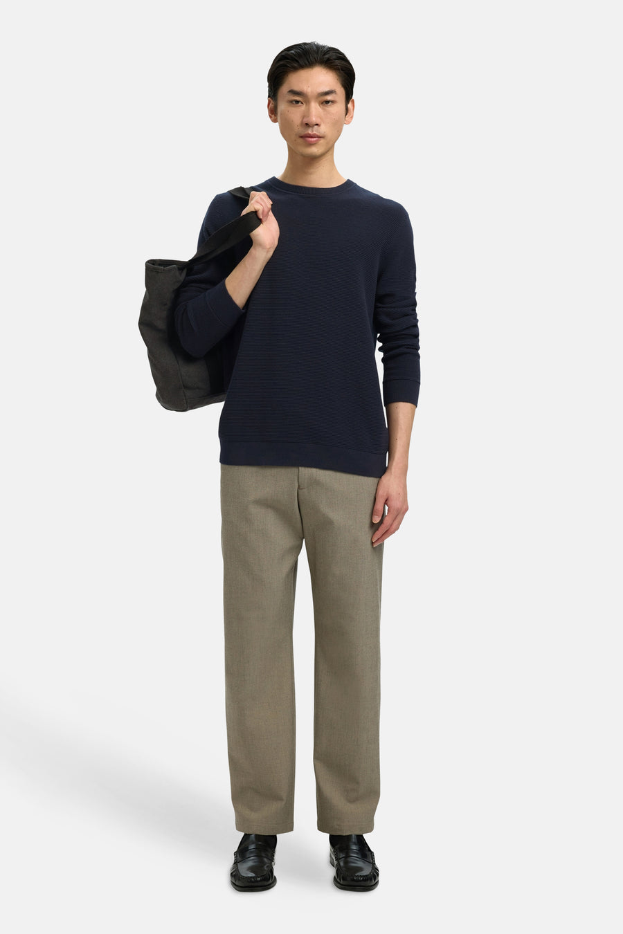 Donkerblauwe coltrui van SELECTED, gedragen met een beige broek en een zwarte tas.