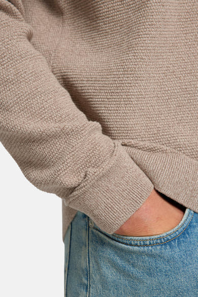Ronde hals trui bruin van SELECTED, gedragen met een blauwe jeans en met een gebreide textuur.