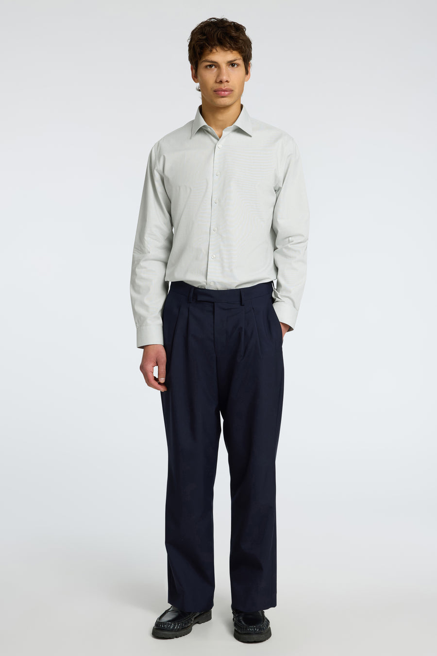 Chemise à manches longues verte de SELECTED, portée avec un pantalon bleu marine ample et des chaussures noires.