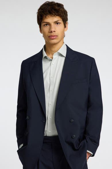 Chemise à manches longues verte de SELECTED, portée sous un veston croisé bleu marine uni.