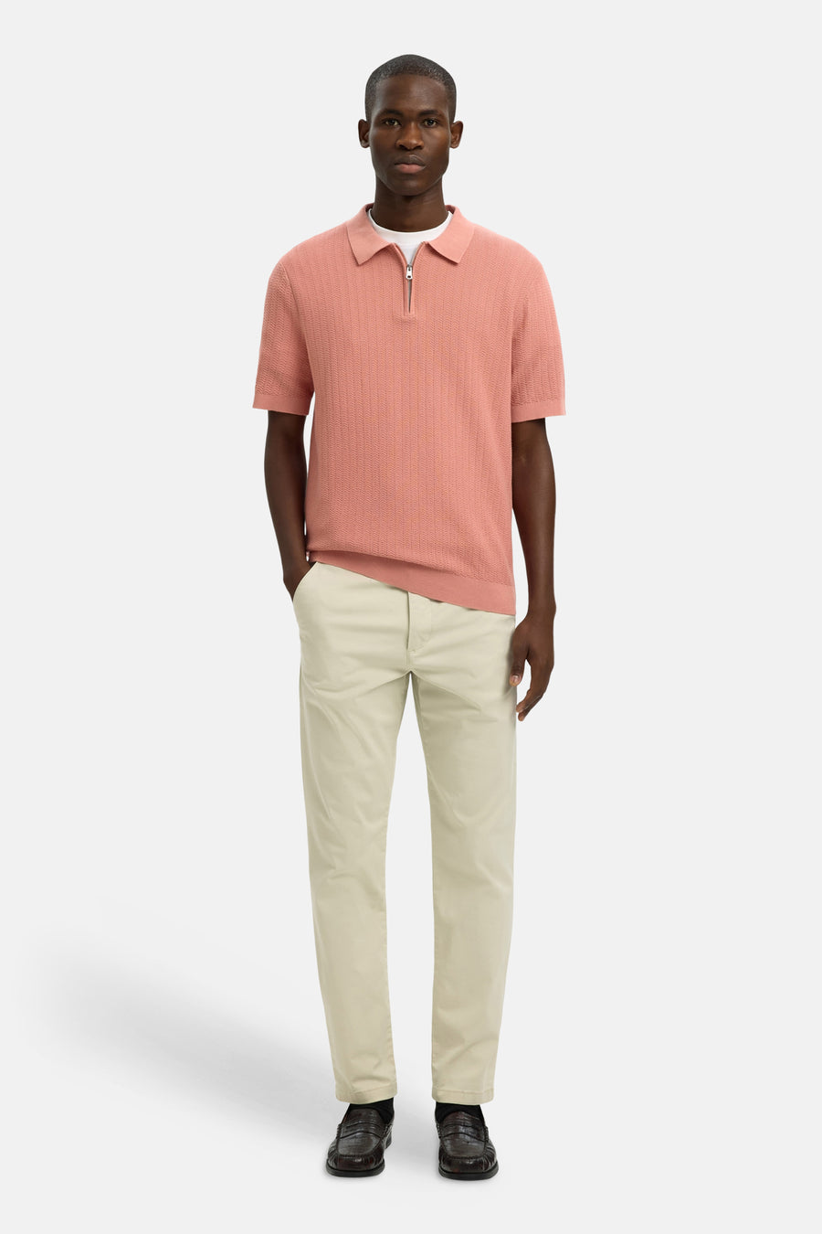 Polo rose en maille gaufrée de SELECTED, porté avec un pantalon chino beige et des mocassins en cuir marron.