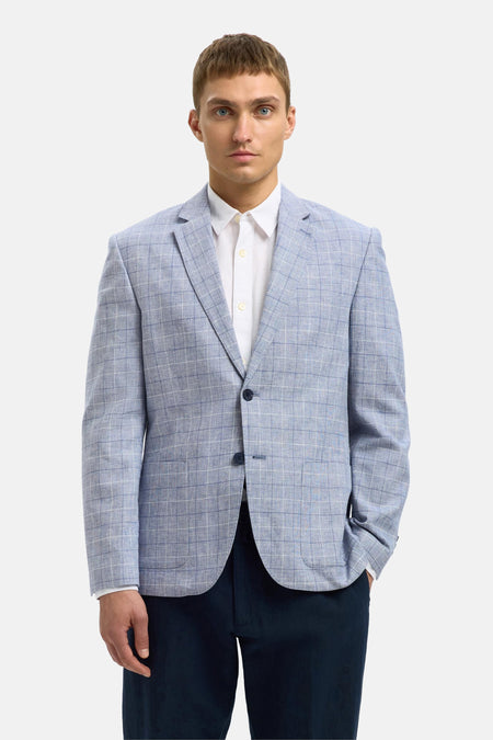 Blauwe blazer van SELECTED met ruitpatroon gedragen over een wit overhemd en een marineblauwe broek.