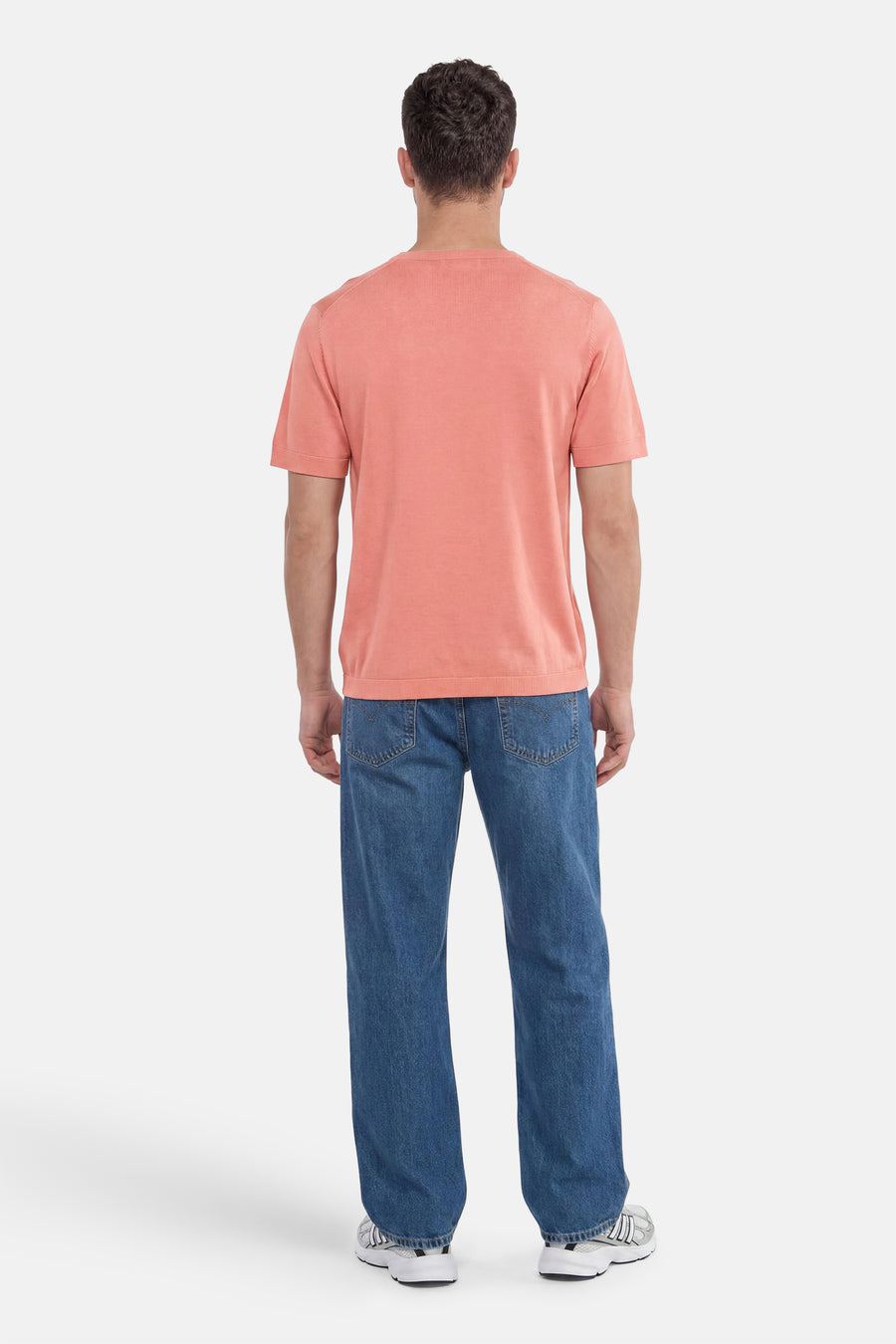 Pull rose de SELECTED à manches courtes, porté de dos avec un jean bleu et des baskets.