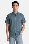 Chemise verte à manches courtes de SELECTED, en tissu légèrement texturé avec des boutons blancs, portée par un homme.