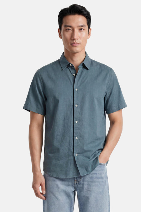 Chemise verte à manches courtes de SELECTED, en tissu légèrement texturé avec des boutons blancs, portée par un homme.