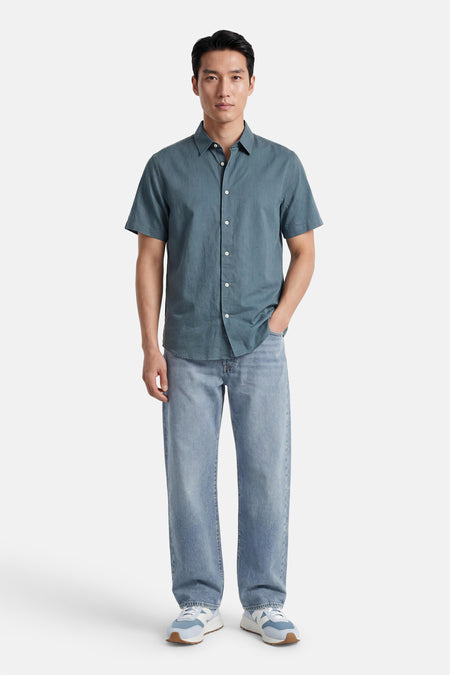Chemise à manches courtes verte de SELECTED, avec des boutons blancs et une légère texture, portée par un homme avec un jean.