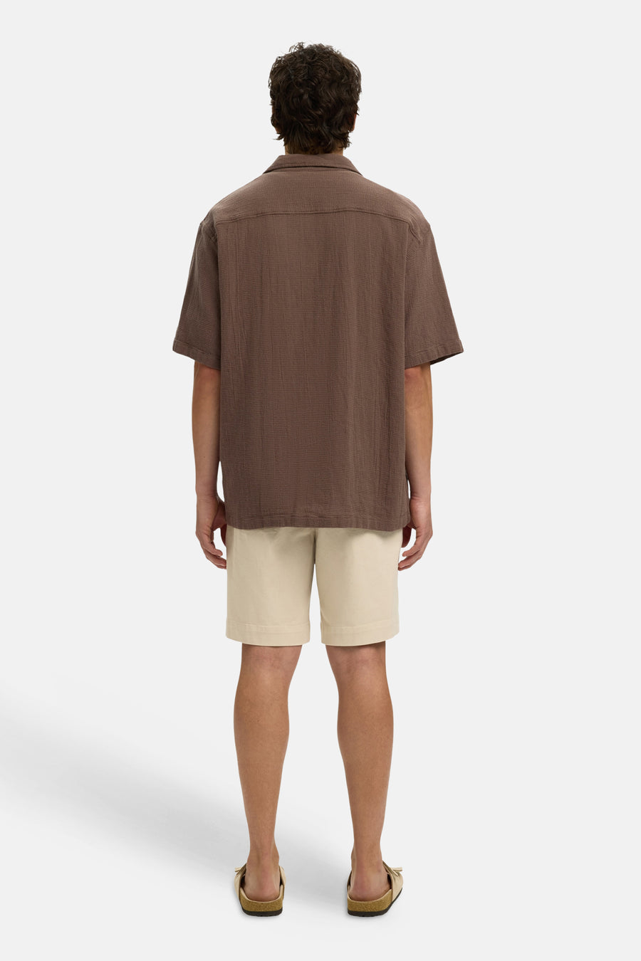 Bruin overhemd met korte mouwen van SELECTED, met getextureerde stof en een losse pasvorm, van achteren gedragen met een beige korte broek en sandalen.