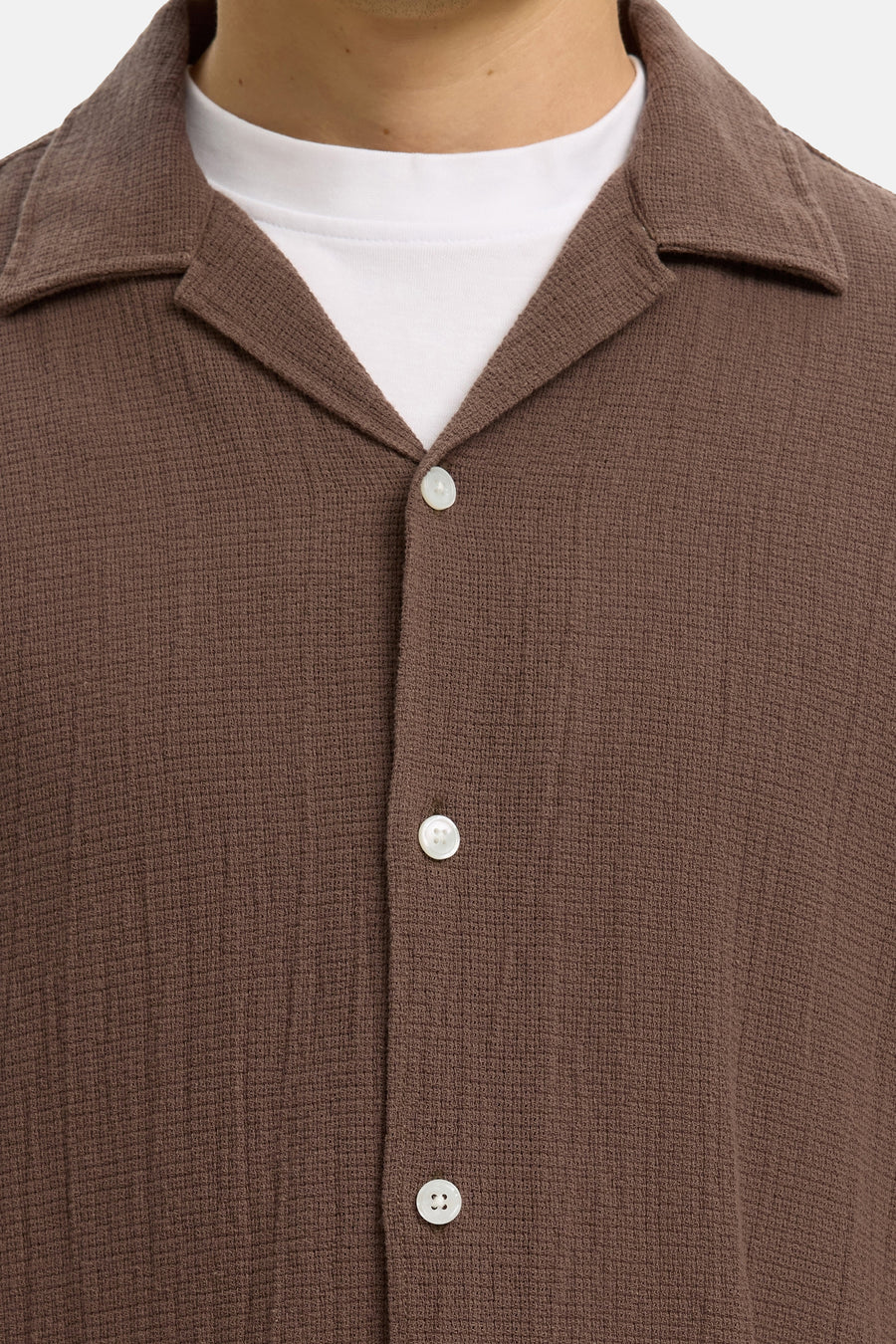 Bruin overhemd van SELECTED met wafeltextuur, met cubaanse kraag en witte knopen, gedragen over een wit T-shirt.