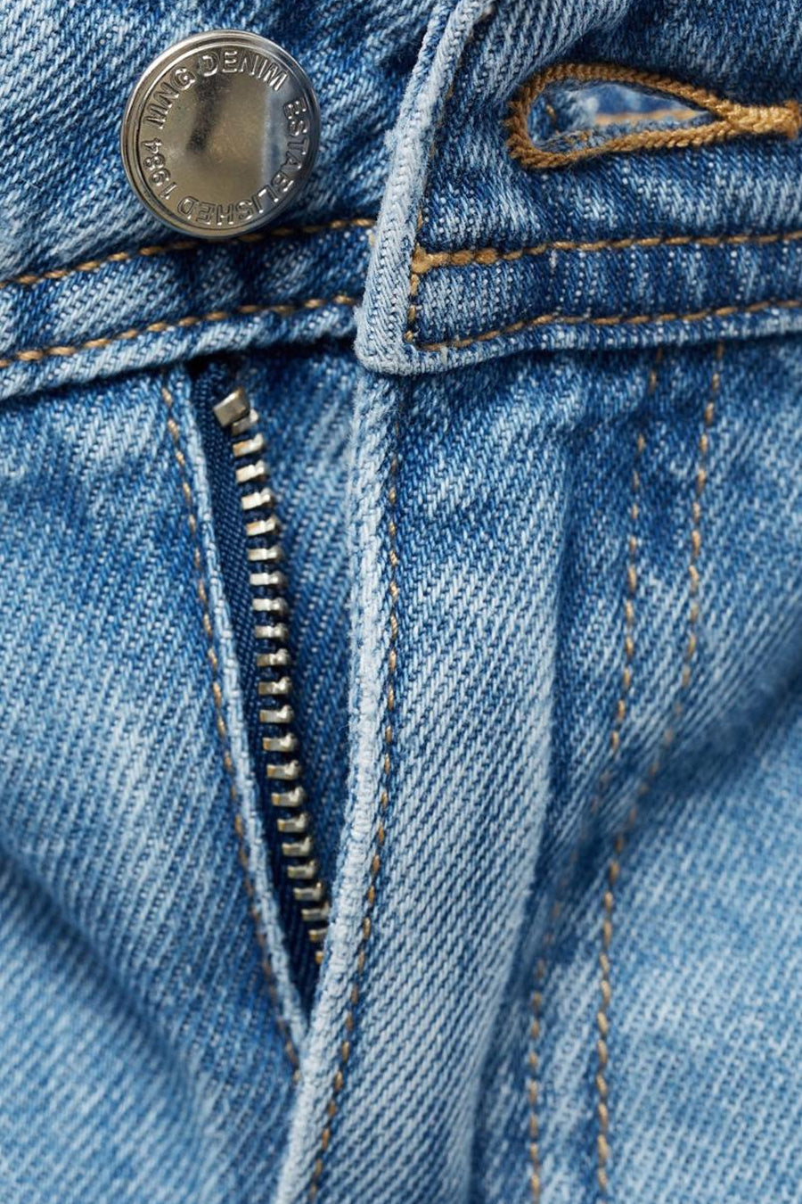 Jean large en denim bleu moyen de MANGO, avec fermeture éclair et bouton argenté.
