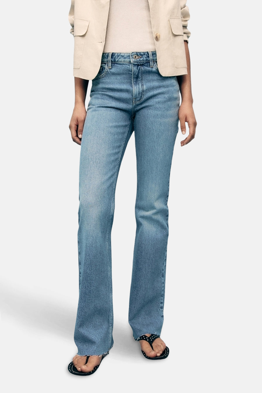 Wijd uitlopende jeans van lichtblauw denim van MANGO, gedragen met een beige blazer.